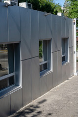 Facade of one-story office building with windows and air conditioning.