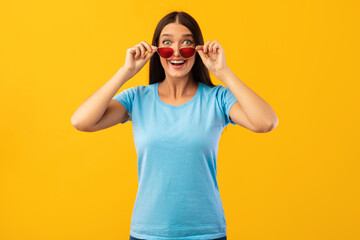 Excited surprised lady looking at camera taking off sunglasses
