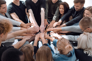 group of diverse people joining their hands in a circle.