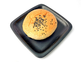 Bread sprinkled with sesame seeds in black tray isolated on white background.