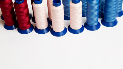 many spools with bright threads for machine sewing on a white background with copy space