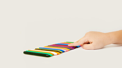 Children hand holding wax crayons on white background.