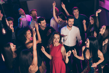 Attractive elegant cheerful glad crowd dancing having fun enjoying celebratory corporate event in dark night music club indoors