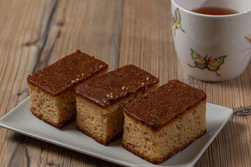 Three pieces of cake and a cup of tea over a wooden table