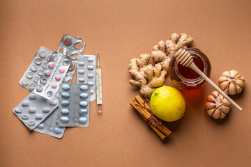 Natural cold and flu home remedies versus synthetic pills and drugs, top view. Honey glass pot,...