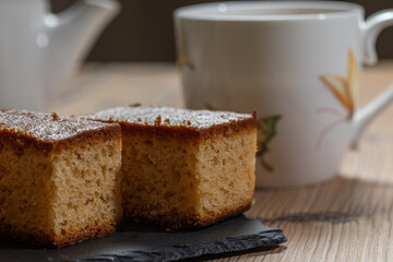 Three pieces of cake and a cup of tea over a wooden table