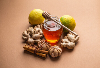 Natural cold and flu home remedies: honey glass pot, ginger, garlic, lemon, cinnamon to boost immune system. Natural healthy food ingredients for immunity stimulation and viruses protection.