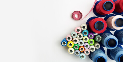 many small and large multicolored spools for sewing machine on the white background with copy space.Top view. Flat lay