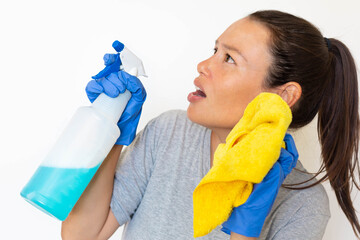 A woman cleaning and sanitizing her home with a rag and spray bottle, afraid of bacteria and germs.