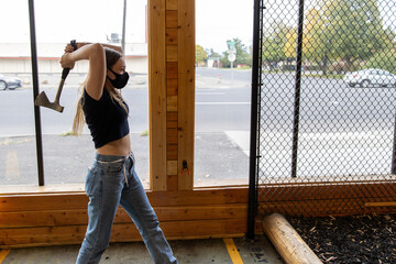 Young girl throws an axe at a target in an axe throwing range