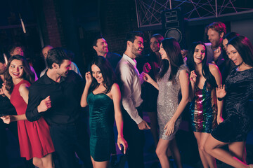 Portrait of nice elegant cheerful beautiful handsome colleagues having fun dancing celebrating corporate festive visiting dark night club indoors