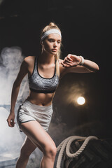 Sportswoman looking at smartwatch getting ready to run in gym
