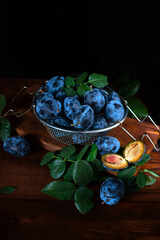 Fresh ripe plums on wooden table.
Farming, gardening, harvesting concept.