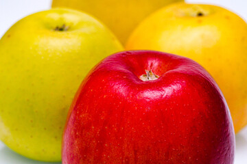 Three juicy ripe apples on a white background, close-up view.
