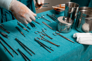 Fototapeta na wymiar Surgeon hand wear medical gloves choosing surgical instruments on a table in operating room