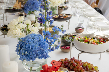 wedding decorations. Served wedding table with decorative fresh fresh flowers and dried flowers. celebration details. flower composition roses plates and candles in candlesticks