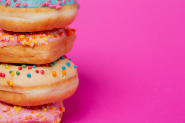 Colored donuts, on a pink background.