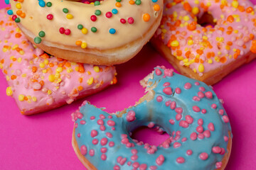 Colored donuts, on a pink background.