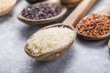Organic white Jasmine rice, unpolished black and brown rice, Riceberry  in wooden spoons