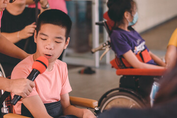 Fototapeta premium Asian special child on wheelchair in classroom for disabilities children with smile happy face while doing activity in school,Life in the education age of disabled kids, Happy disability concept.