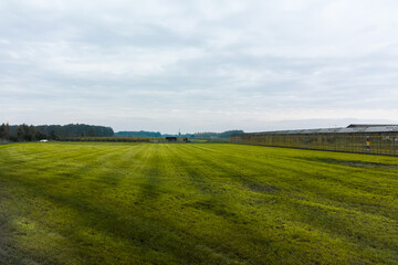 Fototapeta premium Green Dutch landscape with green pasture, old wind mill and clouds