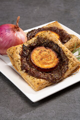 Fresh baked puff tarts with caramelized onion and goat cheese