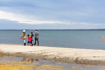 Children walking and adventuring outdoors on beach in fall