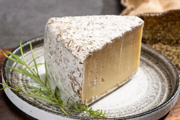 Cheese collection, French tomme cailladou cheese made with aromatic herbs of provence rosematy, thyme,  origano