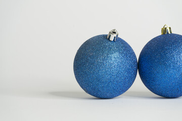 Blue christmas balls white background and last shiny sphere Close up Photo