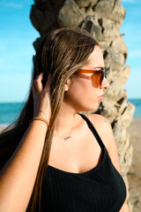 Girl portrait on the beach, sunglasses anda palm tree
