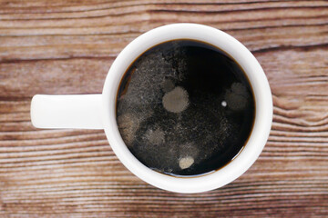 mold in a white mug with a drink on a wood background