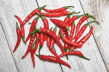 Pile of red, hot, spicy freshly harvested organic dragon cayenne chili peppers on a rustic wooden...