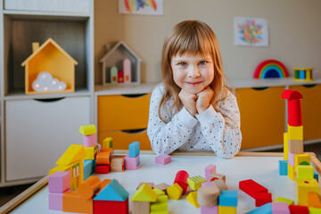 Little girl playing with wooden cubes