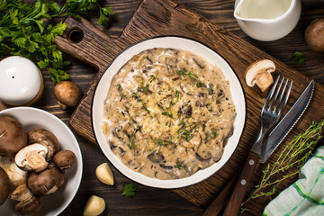 Champignons in cream sauce at white table.