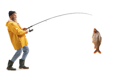 Full length profile shot of a bearded fisherman catching a big fish