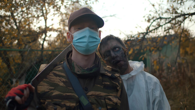 Portrait of zombie standing behind young hunter male