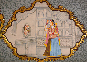 Honorable Indian woman looking in mirror in dressing room - ancient wall painting of Patwon Ki Haveli in Jaisalmer, Rajasthan, India. A haveli is a traditional townhouse or mansion in India.