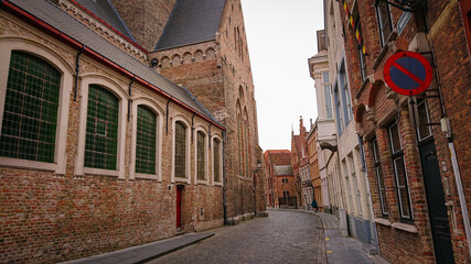 Fototapeta premium Bruges, Belgium - May 12, 2018: Roofs And Windows Of Old Authentic Brick Houses On Street Sint-Jakobsstraat