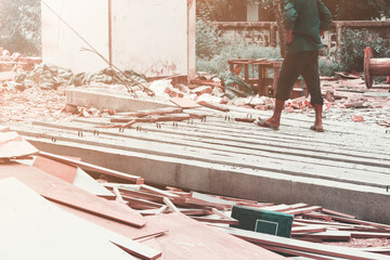 worker move pile concrete pillars on ground by sling in construction site