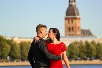 Young couple in love embraced together, isolated on cityscape.  Concepts about travel, relationships and lifestyle.