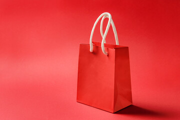 Red paper bag on a red background with copy space.