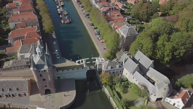 Flight over a few buildings on a waterway in Zierikzee in Zeeland. In the south of the Netherlands. Red roofs in sunny weather and a few ships in the waterways.