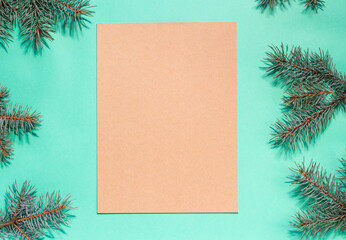 Christmas flat lay of fir branches on the turquoise background with copy space. Image for Christmas greeting cards and articles. Winter, New Year, Christmas concept