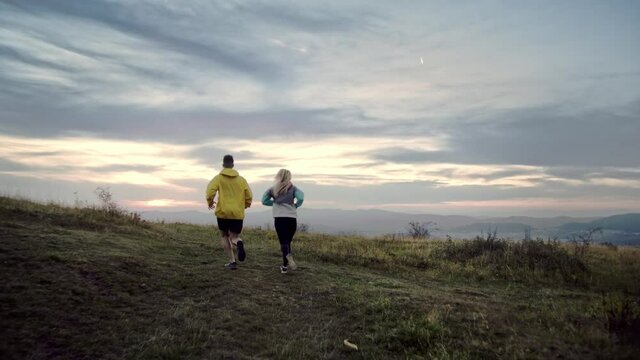 Evening run, Sport couple running in the nature at evening. 4K slow motion video