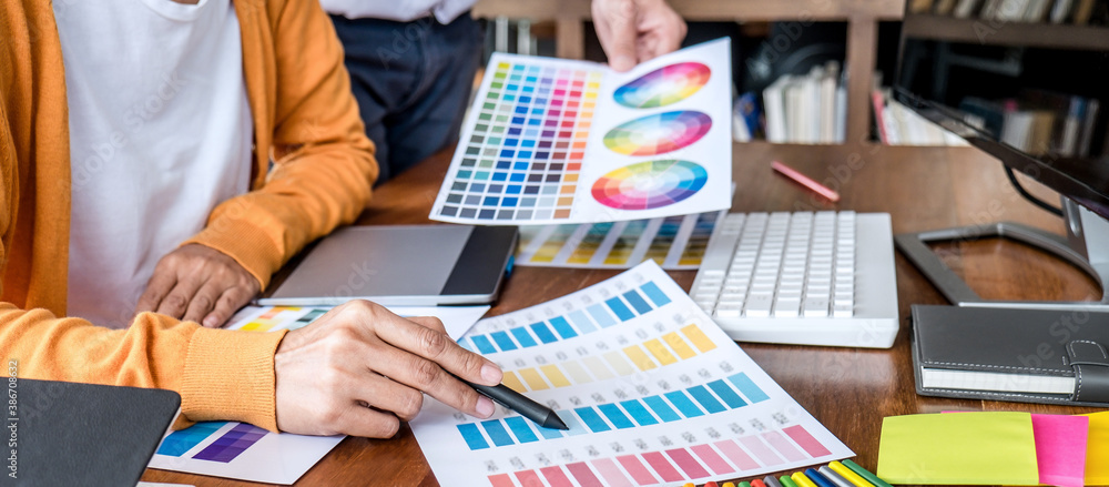 Poster two colleagues creative graphic designer working on color selection and drawing on graphics tablet a