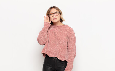 young pretty woman looking serious and curious, listening, trying to hear a secret conversation or...