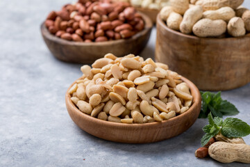 Roasted salted peanuts. Crispy nuts in bowl on stone table.