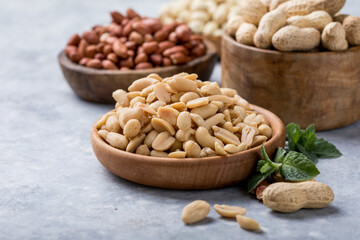 Roasted salted peanuts. Crispy nuts in bowl on stone table.