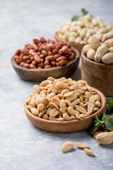 Roasted salted peanuts. Crispy nuts in bowl on stone table.