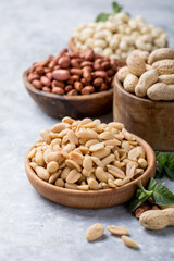 Roasted salted peanuts. Crispy nuts in bowl on stone table.